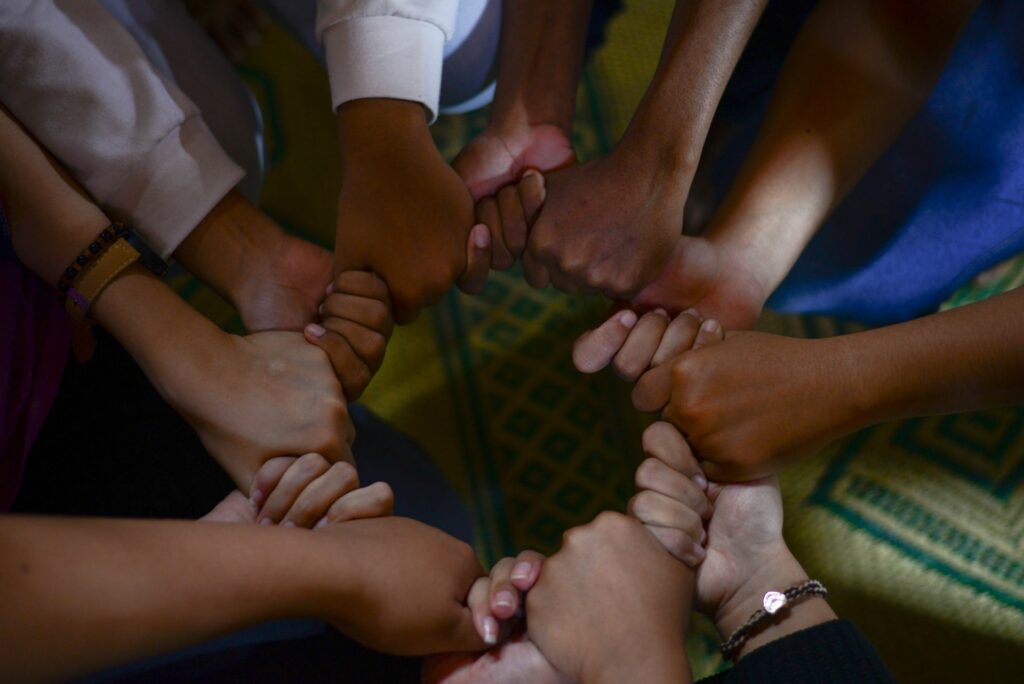 People holding hands in a circle - intercultural counselling