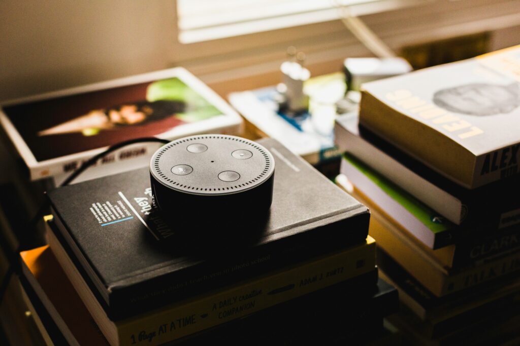 Online counselling. Photo of a voice assistant device on top of a pile of books.