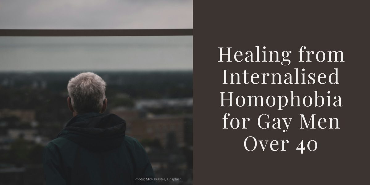 Older man with grey hair seen from behind, looking out over a cityscape on a cloudy day. Beside him is text that reads: 'Healing from Internalised Homophobia for Gay Men Over 40'.